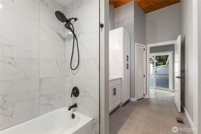 bathroom featuring tile patterned floors, visible vents, baseboards, bathing tub / shower combination, and vanity