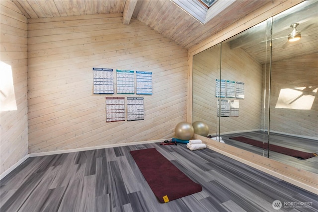 workout area featuring vaulted ceiling with skylight, wooden ceiling, baseboards, and wood finished floors