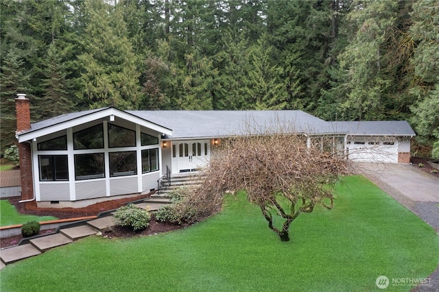 view of front of property with a front yard, a chimney, a garage, crawl space, and driveway