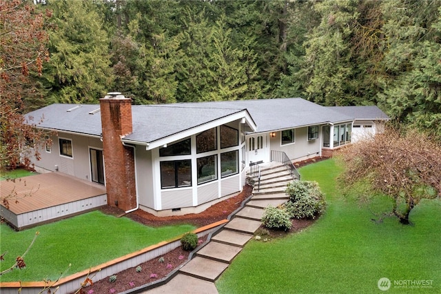 view of front facade with crawl space, roof with shingles, a chimney, and a front lawn