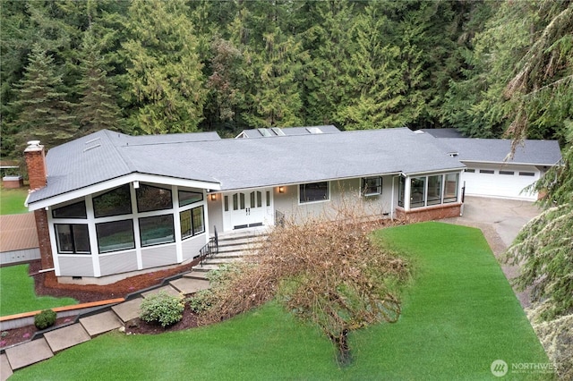 ranch-style home featuring driveway, an attached garage, a front yard, crawl space, and a chimney