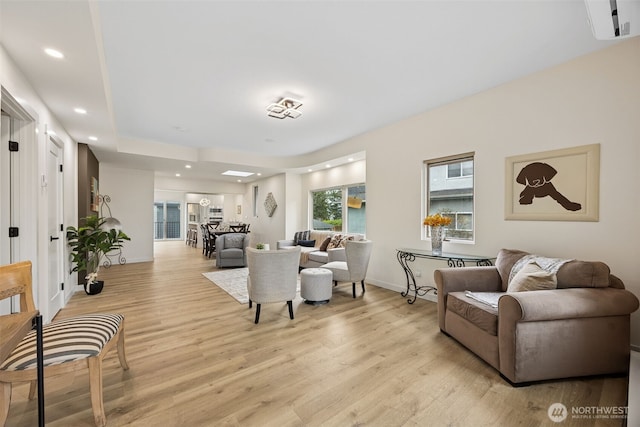 living room featuring recessed lighting, baseboards, and light wood-style floors