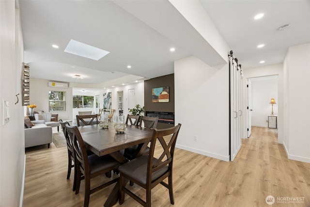 dining room featuring recessed lighting, a barn door, and light wood-style floors