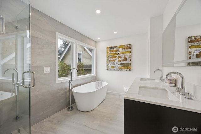 bathroom featuring a shower stall, a freestanding tub, double vanity, and a sink