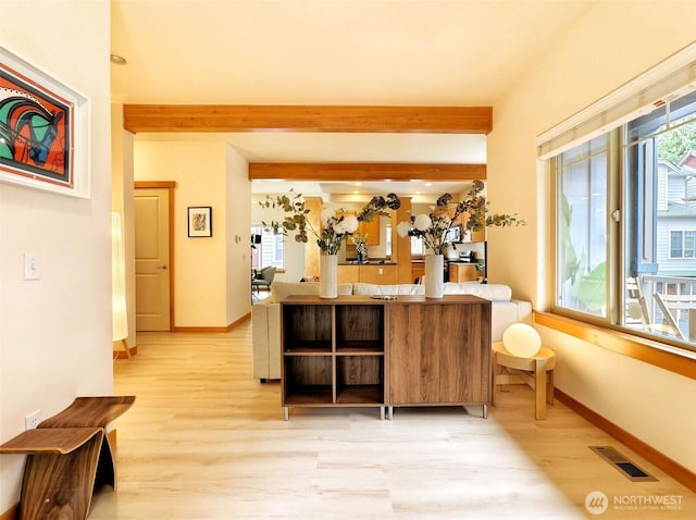 bar featuring light wood finished floors, visible vents, and beamed ceiling