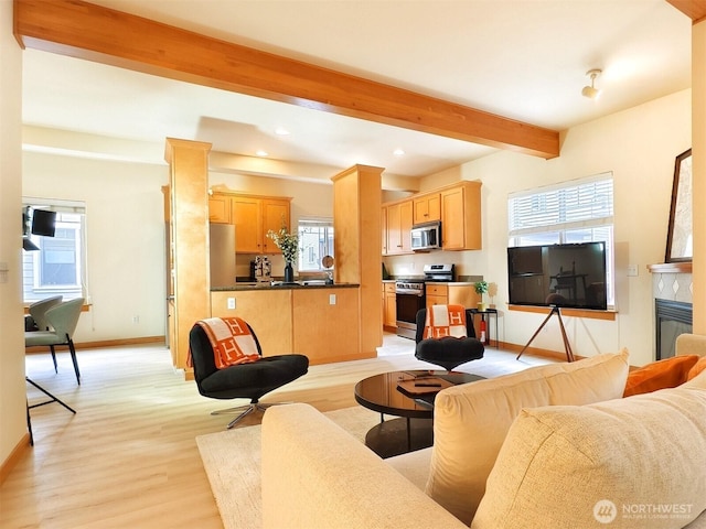 living room with baseboards, light wood-style flooring, recessed lighting, a glass covered fireplace, and beamed ceiling