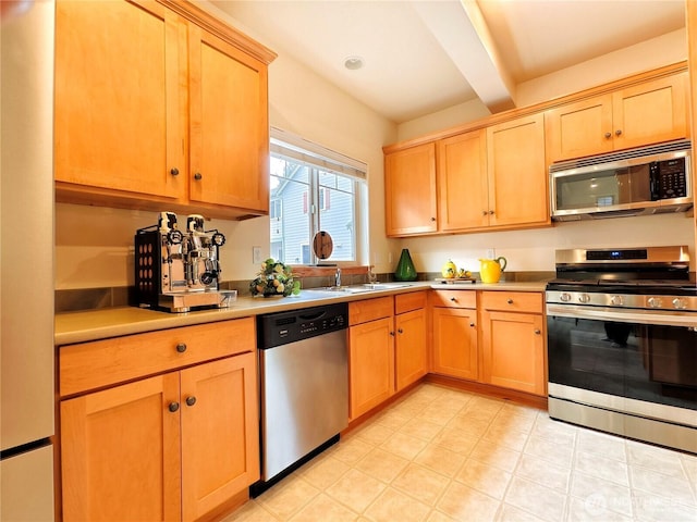 kitchen with light brown cabinets, beamed ceiling, light countertops, stainless steel appliances, and a sink