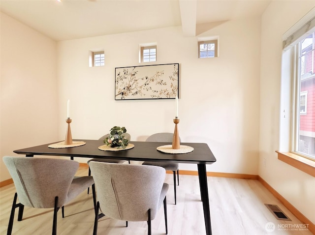 dining space featuring light wood finished floors, visible vents, plenty of natural light, and baseboards