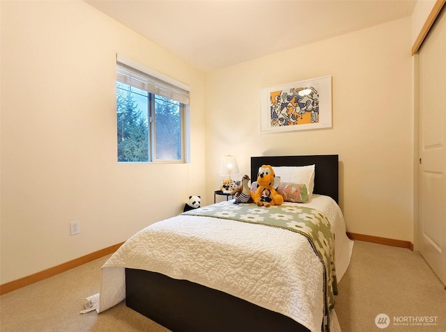 carpeted bedroom with baseboards and a closet