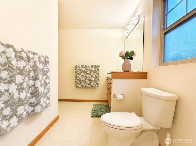 half bath featuring baseboards and toilet