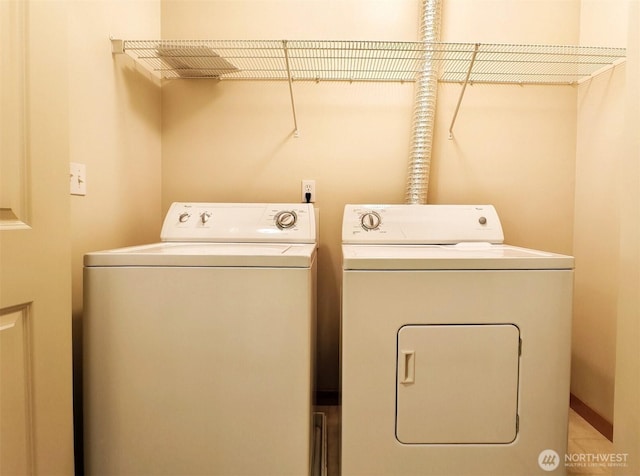 clothes washing area featuring separate washer and dryer and laundry area