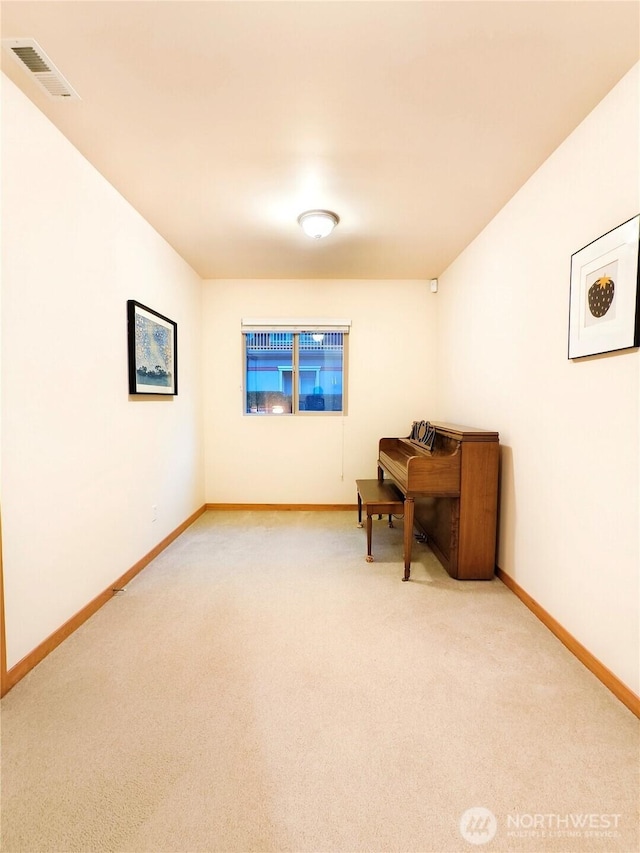 sitting room featuring visible vents, baseboards, and light colored carpet