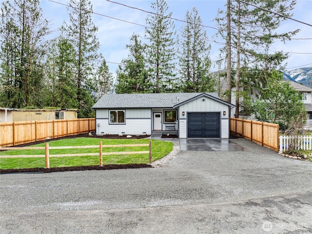 view of front facade with crawl space, an attached garage, a front yard, and fence