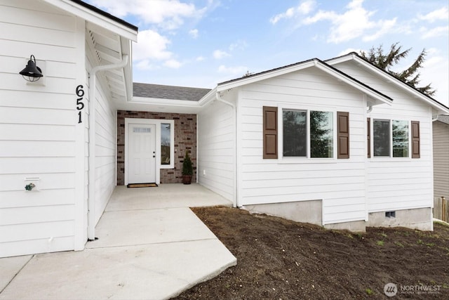 entrance to property featuring crawl space and a shingled roof