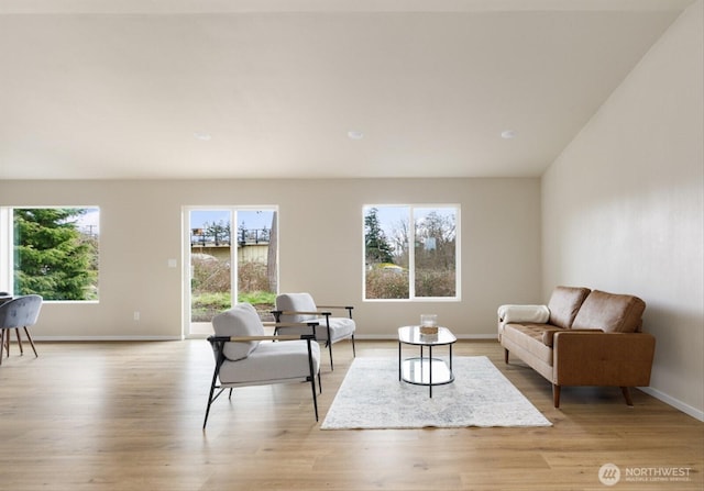 living area with baseboards and light wood finished floors