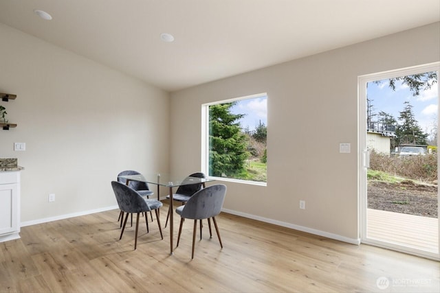 dining area featuring light wood finished floors and baseboards