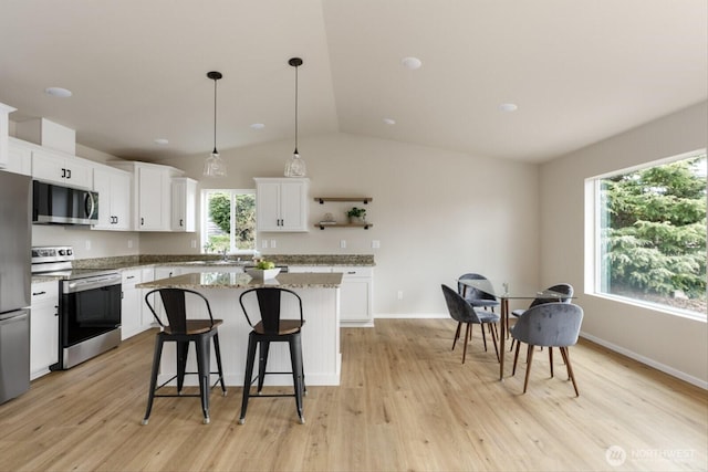 kitchen featuring light wood finished floors, a center island, white cabinets, stainless steel appliances, and open shelves