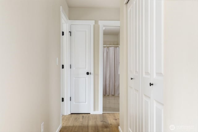 hall featuring wood finished floors and baseboards