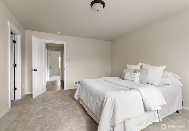 bedroom featuring visible vents, baseboards, and light colored carpet