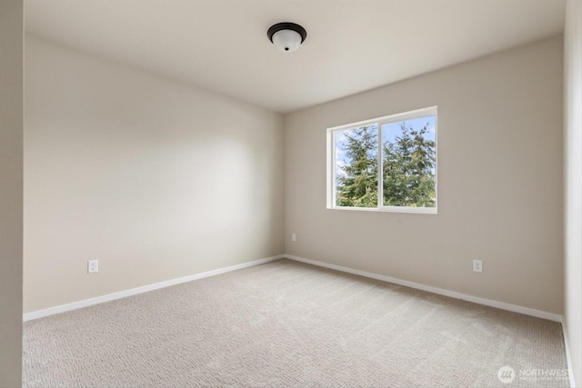 empty room with light colored carpet and baseboards