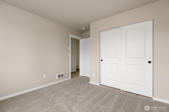 unfurnished bedroom with carpet flooring, baseboards, visible vents, and a closet