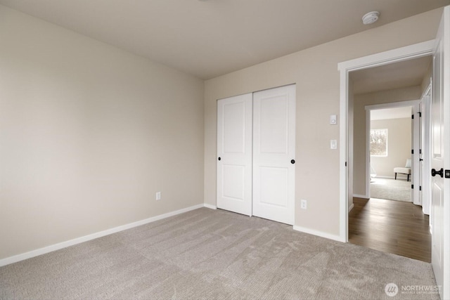 unfurnished bedroom with a closet, baseboards, and carpet flooring