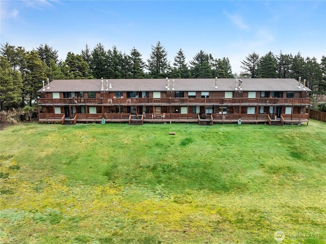 rear view of property featuring a yard and a deck