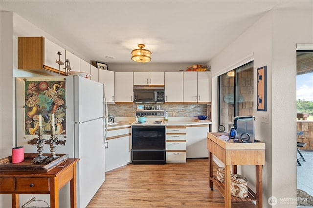 kitchen featuring white appliances, decorative backsplash, light countertops, white cabinets, and light wood-type flooring