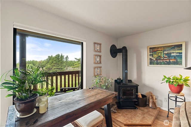 dining area with a wood stove and wood finished floors