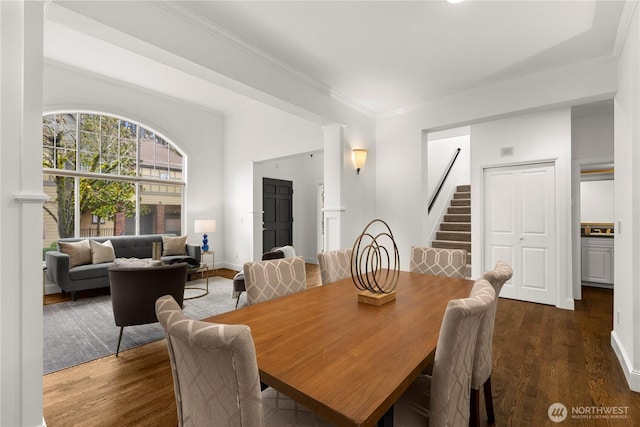 dining room with stairs, crown molding, wood finished floors, and baseboards