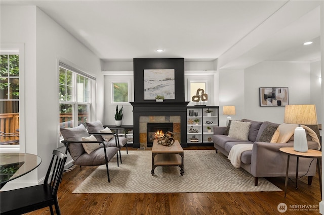 living area featuring a tiled fireplace, recessed lighting, and wood finished floors