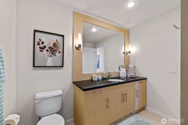 bathroom featuring toilet, recessed lighting, vanity, and baseboards