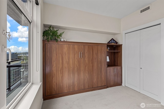interior space with visible vents, access to exterior, a closet, and light carpet