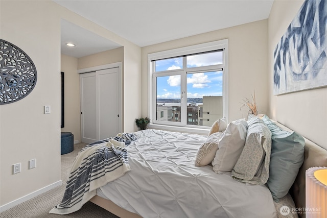 carpeted bedroom with a closet and baseboards