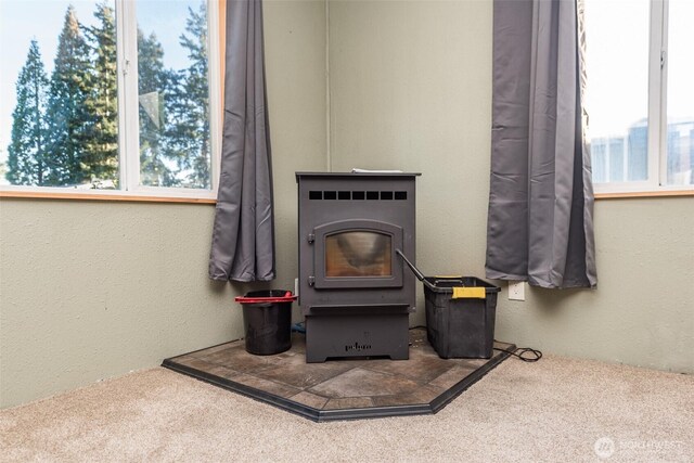 room details featuring a wood stove and a textured wall