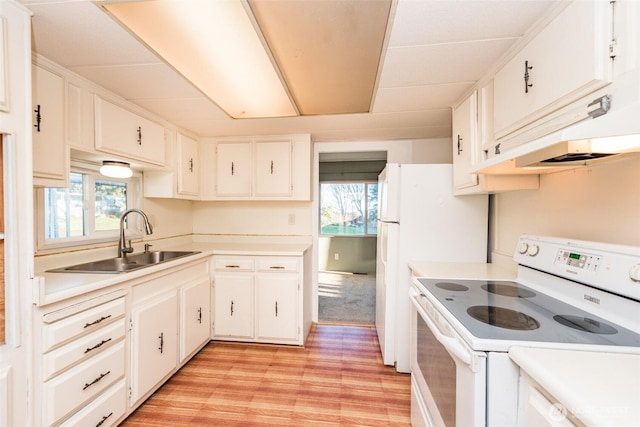 kitchen with a sink, light countertops, white cabinets, under cabinet range hood, and white range with electric stovetop