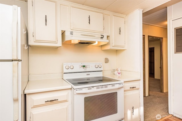 kitchen featuring white appliances, light countertops, light colored carpet, and under cabinet range hood