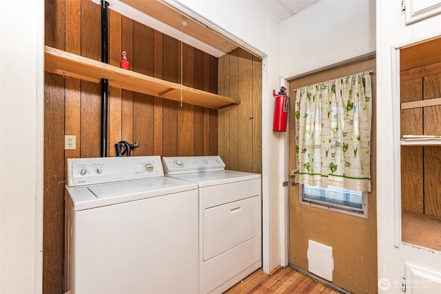 clothes washing area featuring laundry area, light wood-style floors, and separate washer and dryer