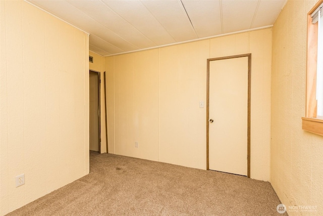 carpeted spare room with visible vents