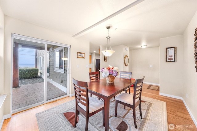 dining space featuring beam ceiling, baseboards, light wood-type flooring, and visible vents