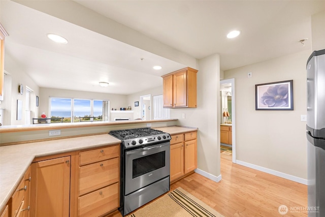 kitchen featuring light wood finished floors, recessed lighting, appliances with stainless steel finishes, and light countertops