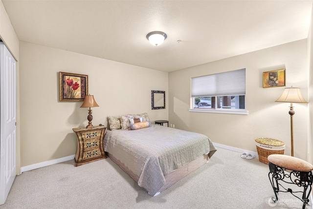 carpeted bedroom featuring baseboards and a closet