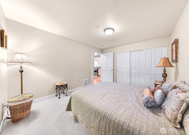 bedroom featuring carpet flooring, visible vents, baseboards, and a closet