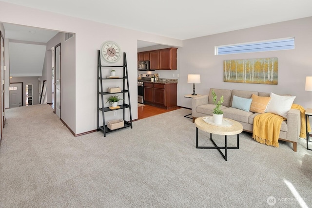 living area with visible vents, baseboards, and light colored carpet