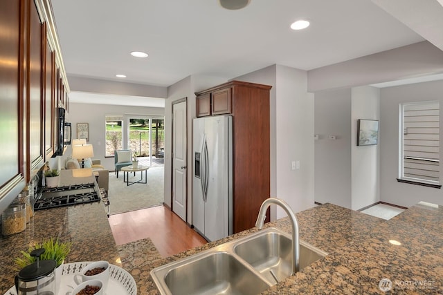 kitchen featuring a sink, recessed lighting, black microwave, and stainless steel fridge with ice dispenser