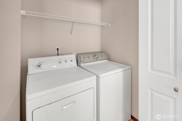 clothes washing area with washing machine and dryer