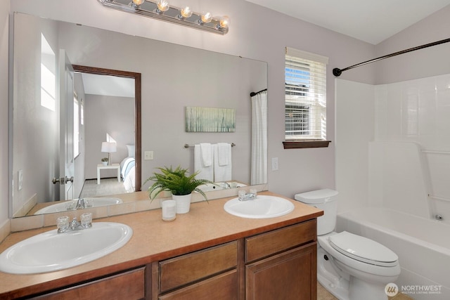 ensuite bathroom featuring a sink, bathing tub / shower combination, toilet, and double vanity