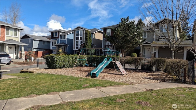 community playground with a residential view and fence