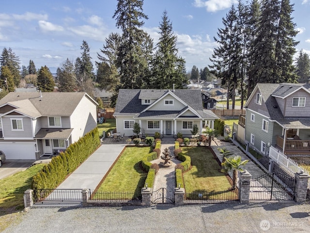 view of front of house with a fenced front yard, a residential view, driveway, and a gate