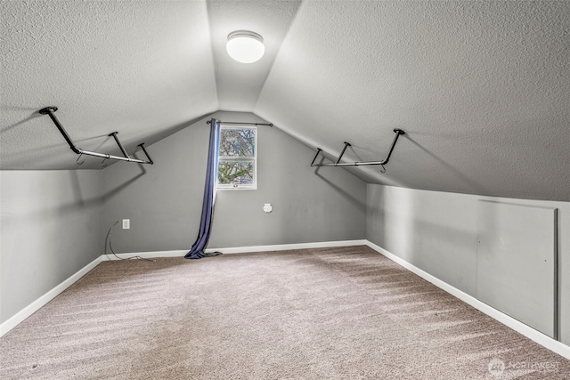 walk in closet with vaulted ceiling and carpet